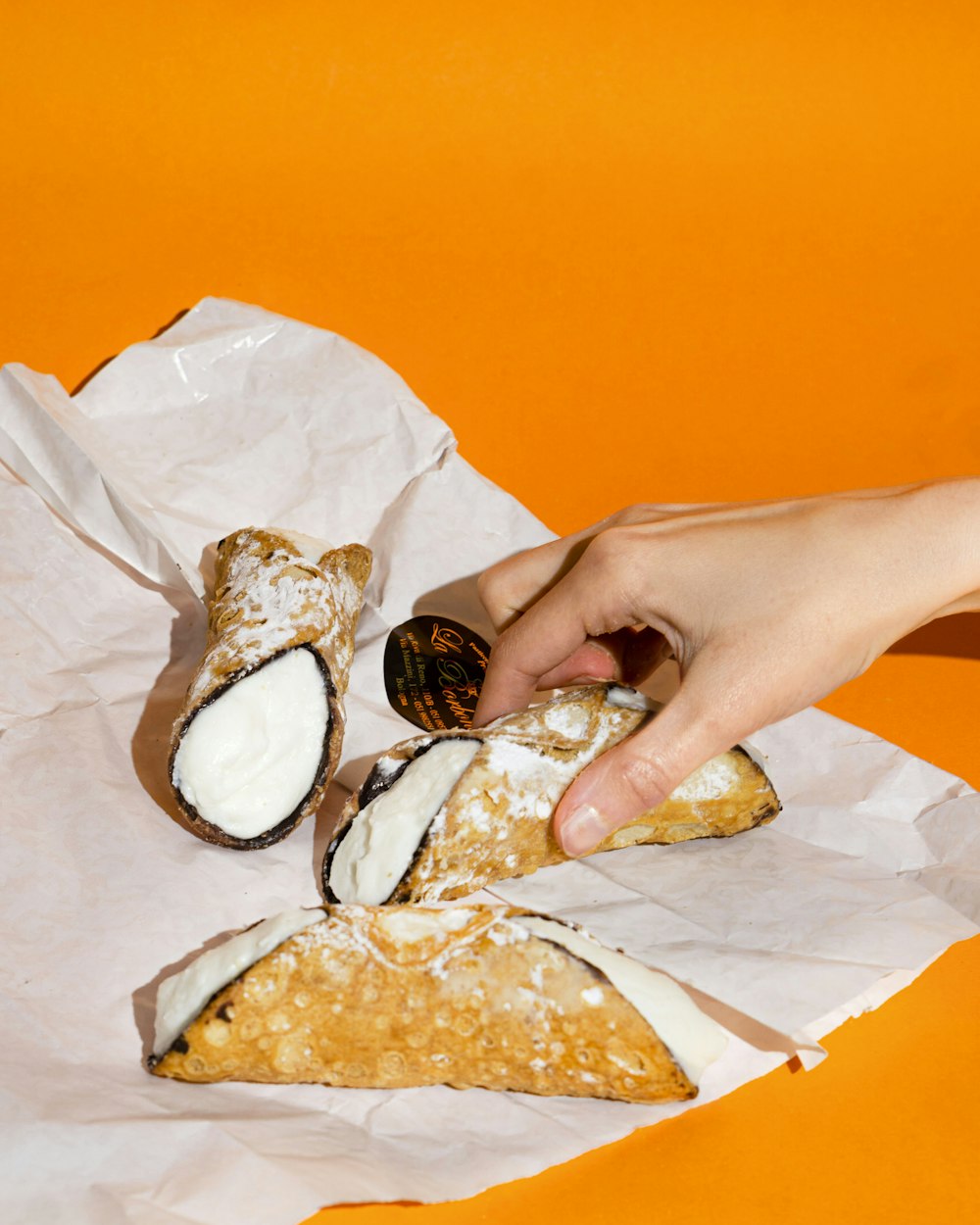 a person grabbing a piece of food from a wrapper