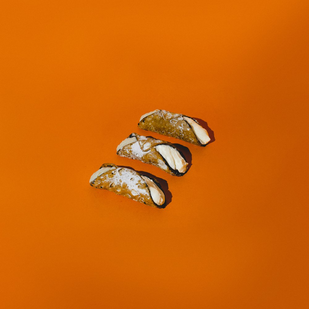 a couple of pieces of food sitting on top of an orange surface