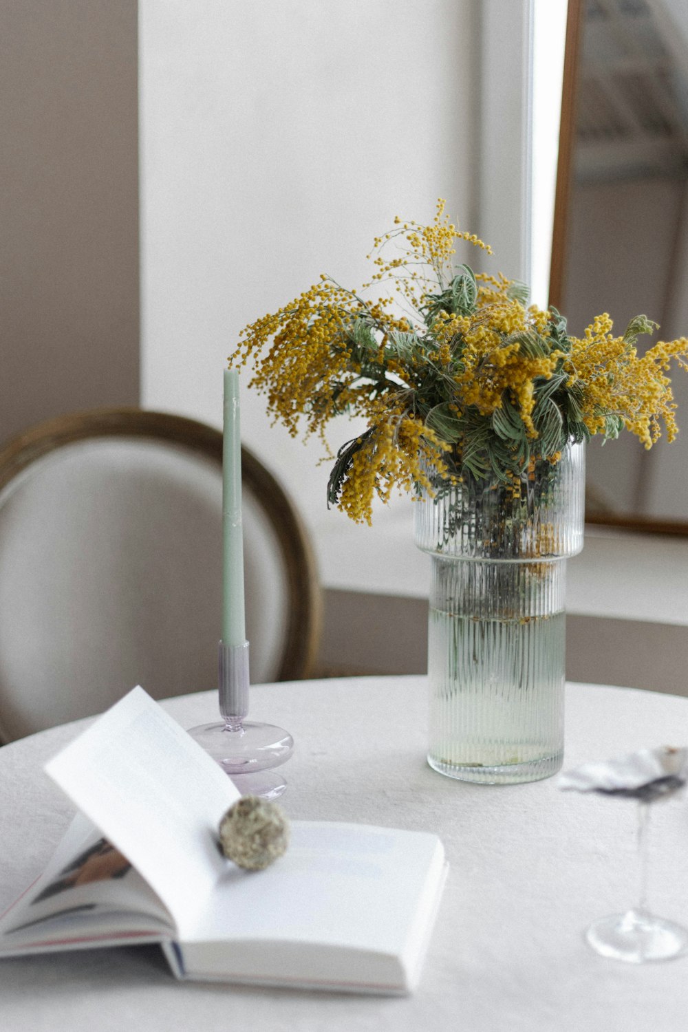 una mesa con un jarrón de flores y un libro en ella