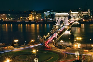 a night time view of a bridge over a river