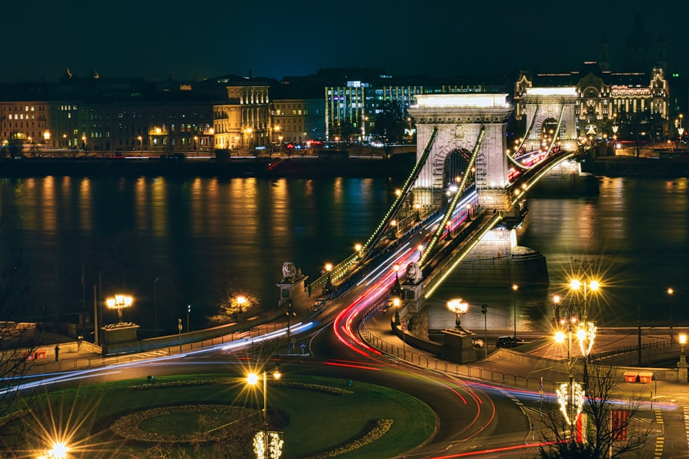 a night time view of a bridge over a river