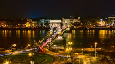 a night time view of a bridge over a river