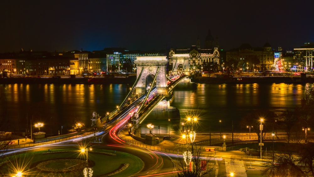 a night time view of a bridge over a river
