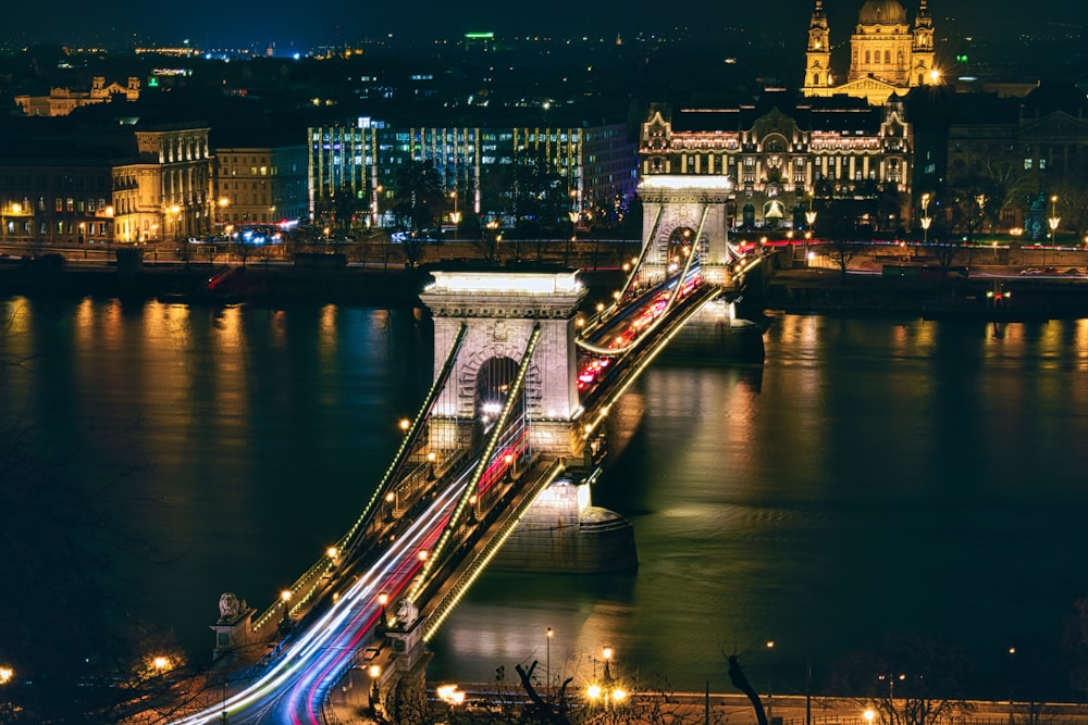 a night time view of a bridge over a body of water