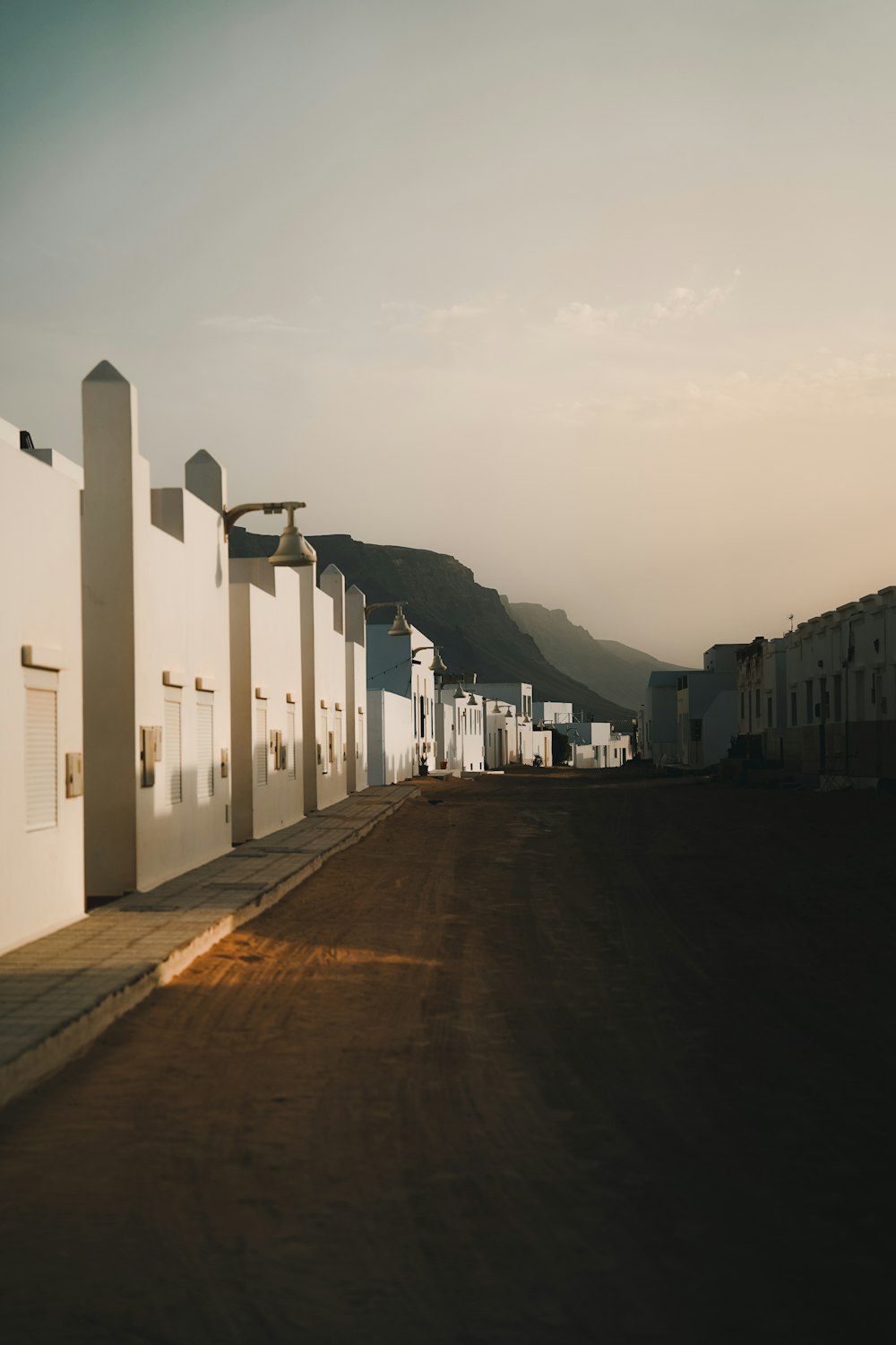 a row of white buildings sitting on the side of a road