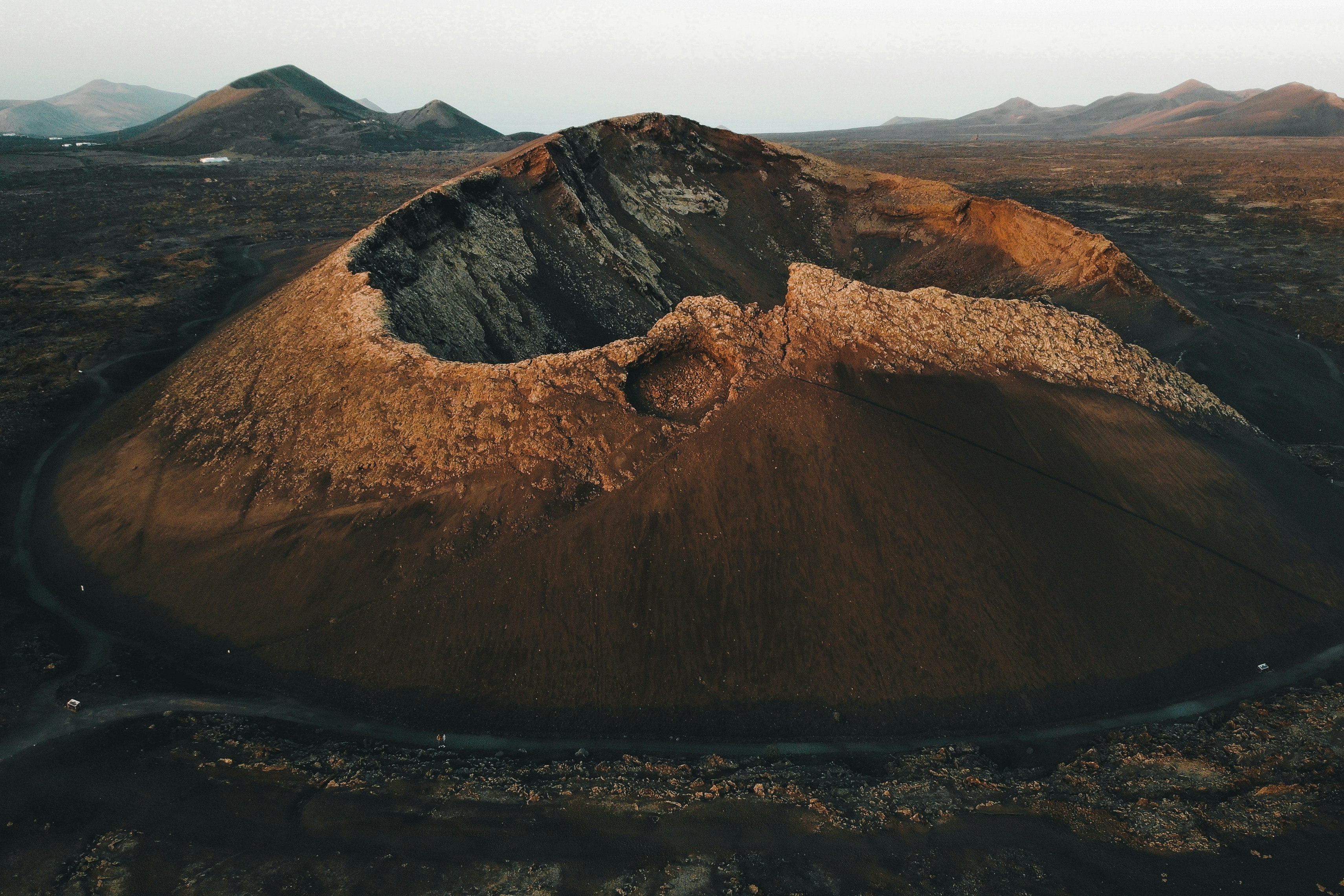 an aerial view of a mountain with a road running through it