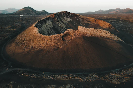 an aerial view of a mountain with a road running through it