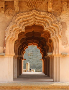 an archway in a stone building with a bench under it
