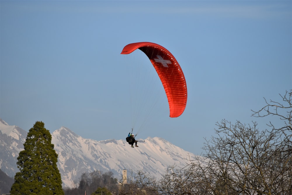 a person is parasailing in front of a mountain range