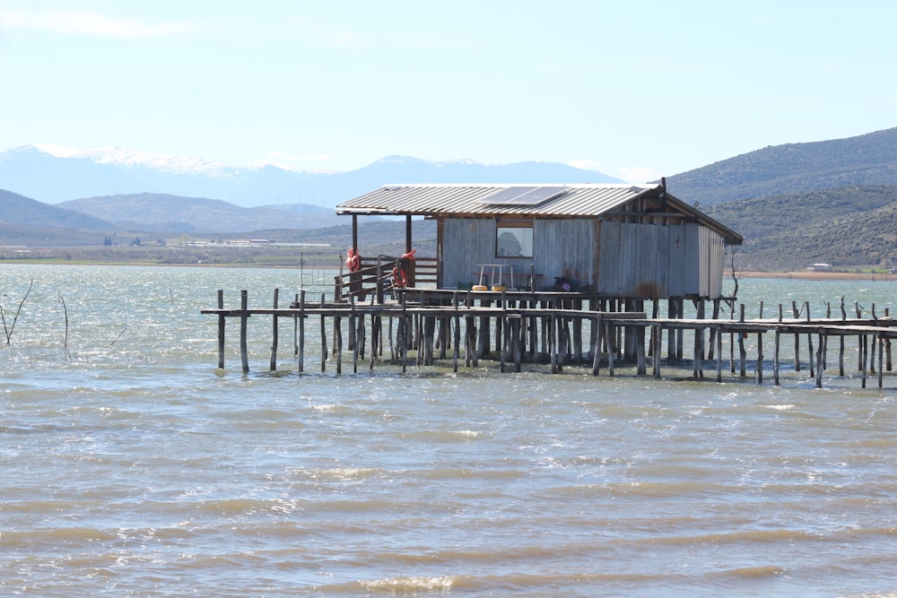 a small shack sitting on top of a wooden pier