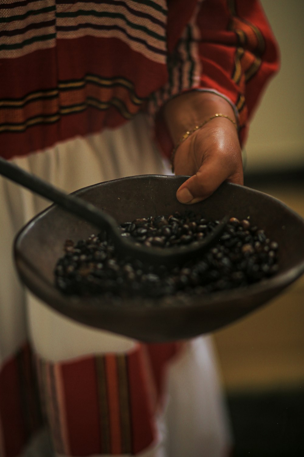 a person holding a bowl of black beans