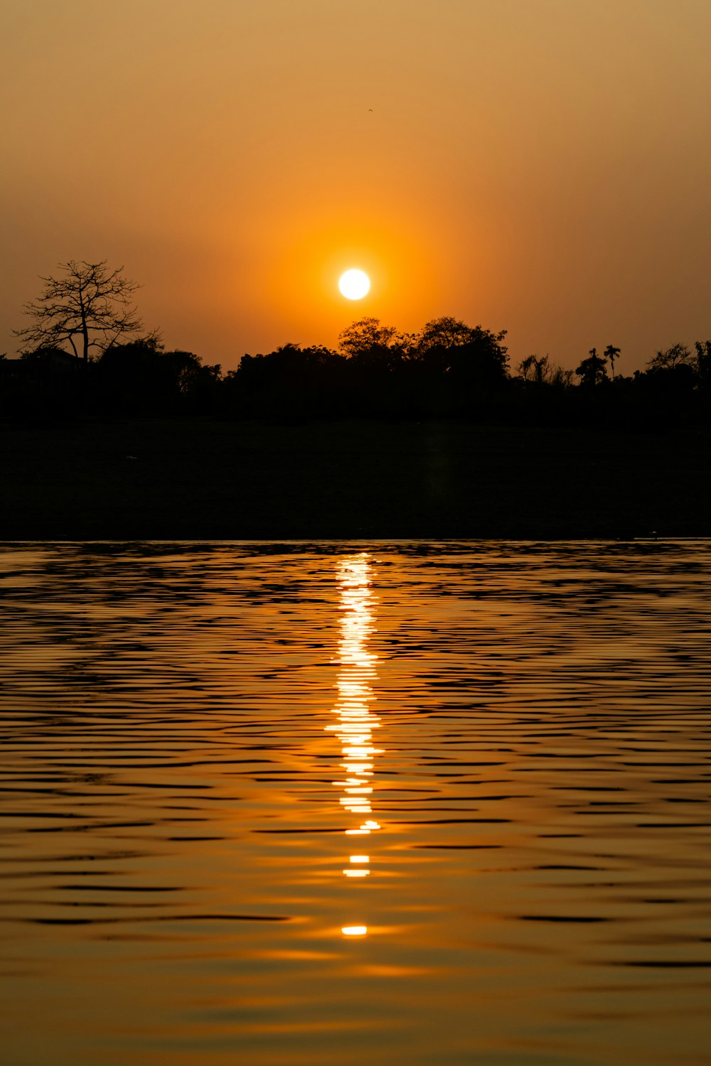 the sun is setting over a body of water