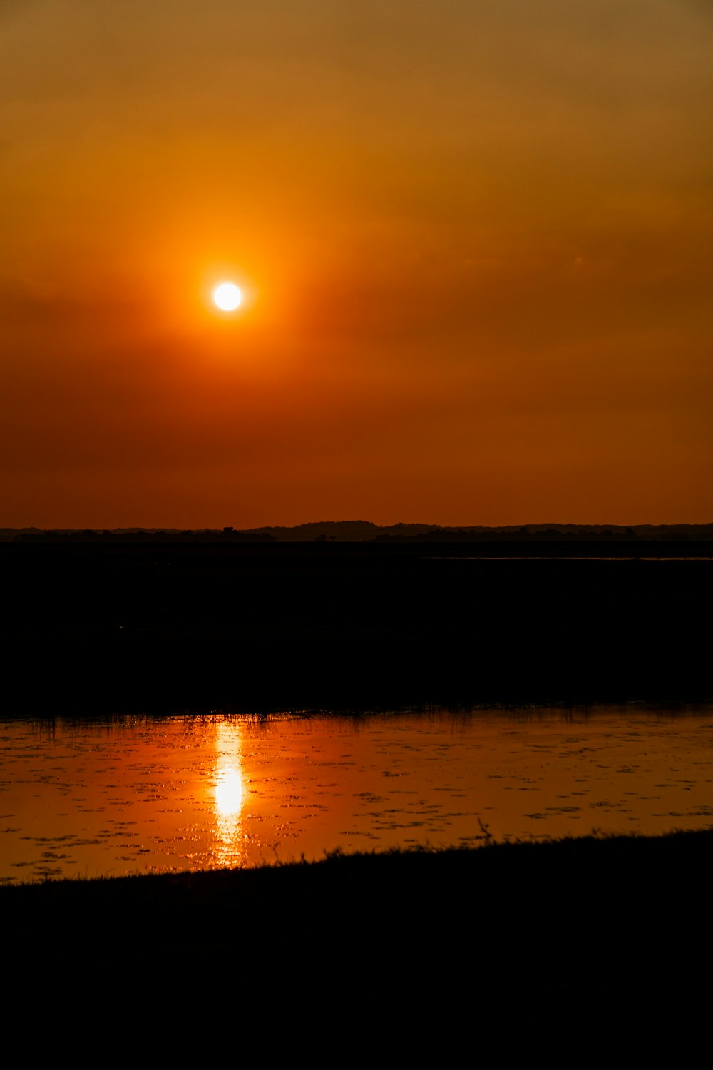 the sun is setting over a body of water