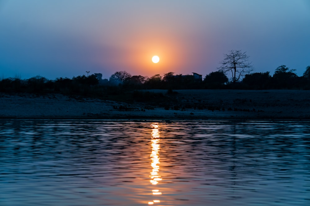 the sun is setting over a body of water