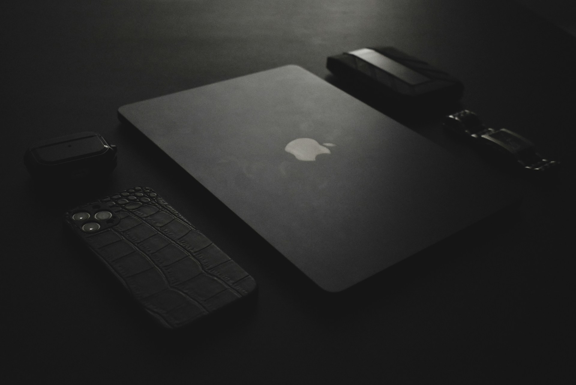 an apple laptop and a cell phone on a table