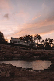 Sunset view of modern beachfront condos with palm trees swaying.