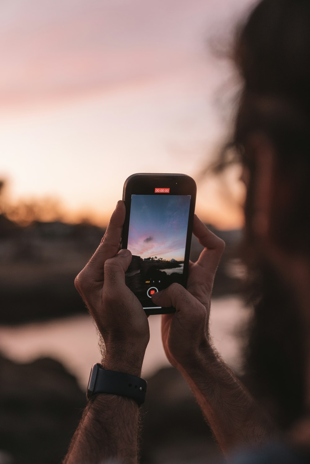 a man holding up a smart phone to take a picture