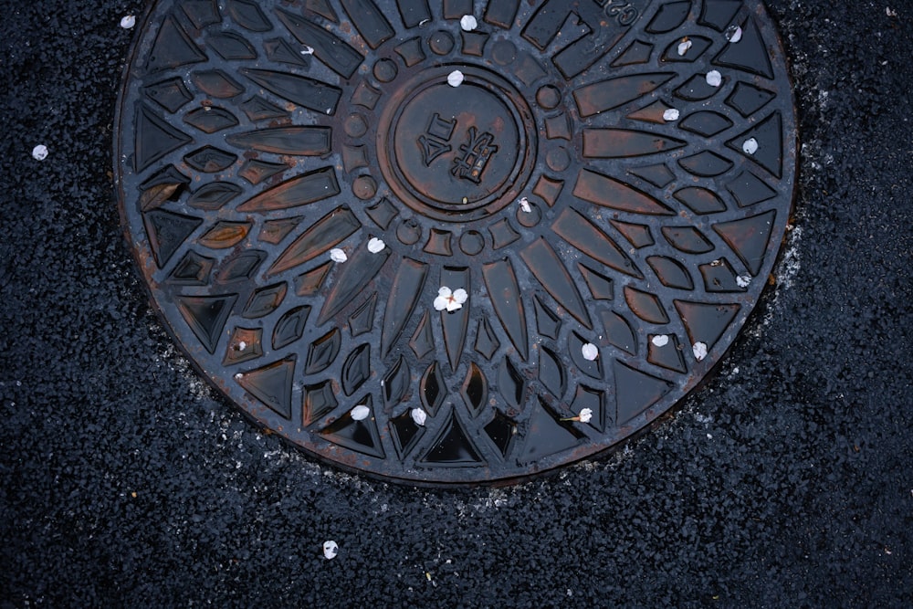 a manhole cover on the ground with flowers on it