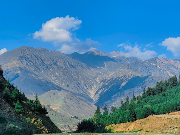 A scenic landscape showcasing a beautiful mountain range under a clear blue sky.