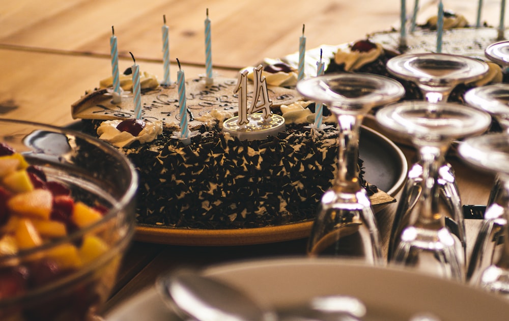 a table topped with a cake covered in chocolate frosting