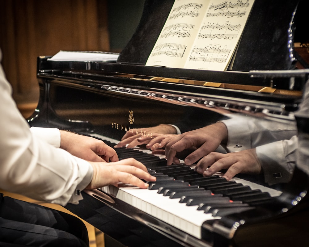 Un par de personas que están sentadas al piano