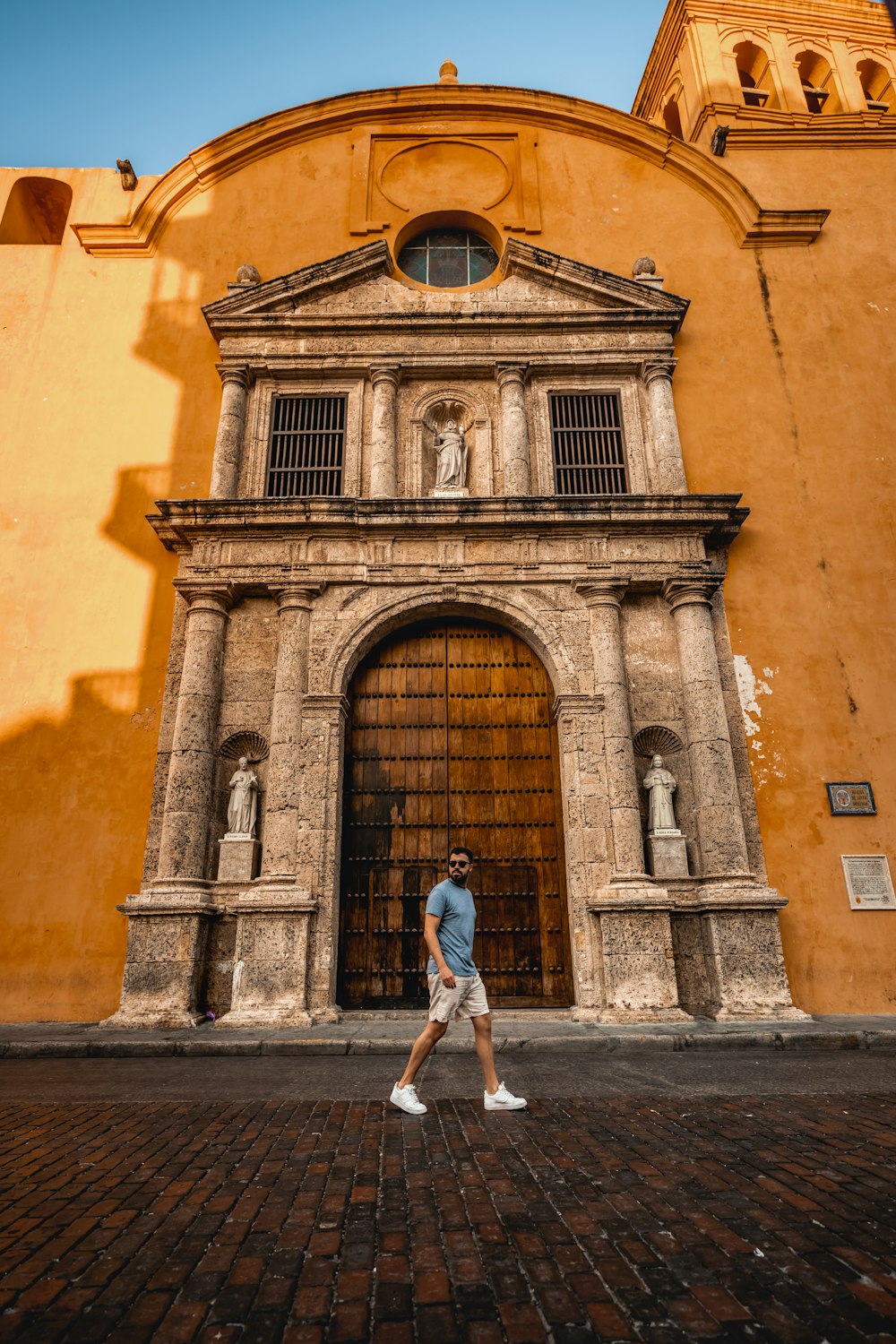 a man walking in front of a tall building