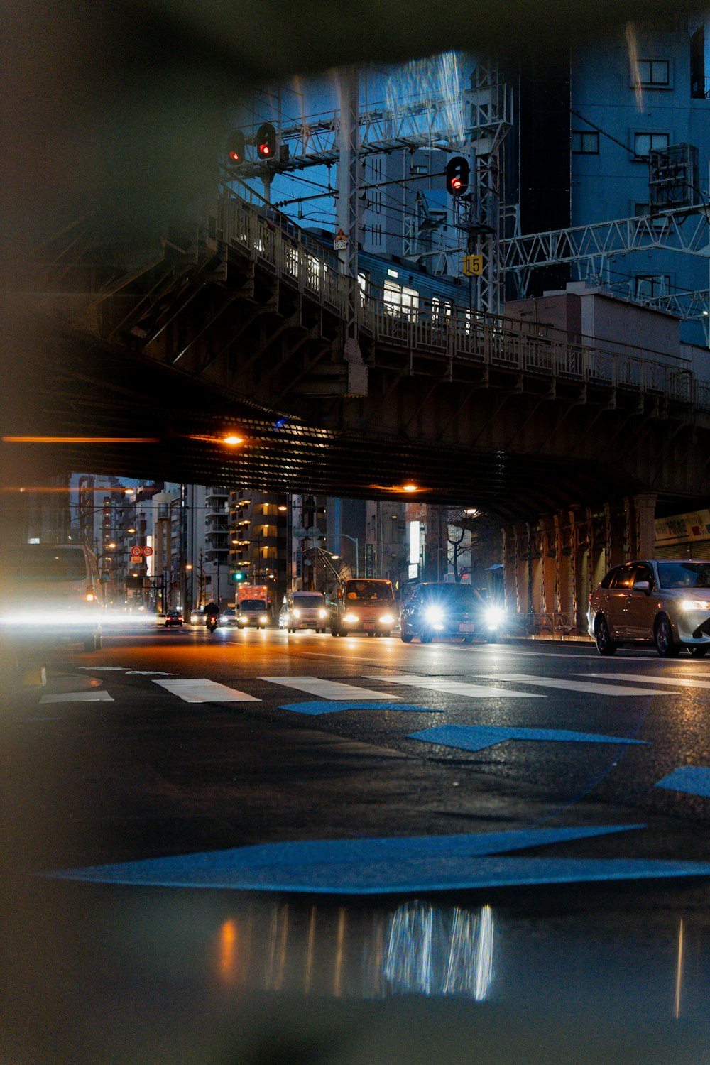 a city street filled with lots of traffic under a bridge