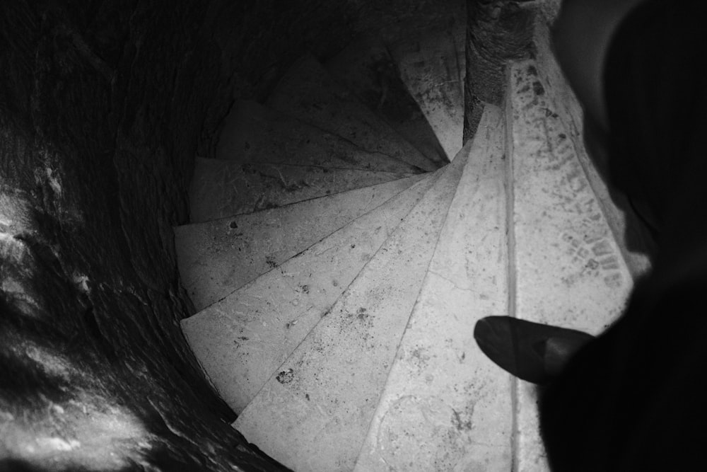 a person standing in front of a spiral staircase