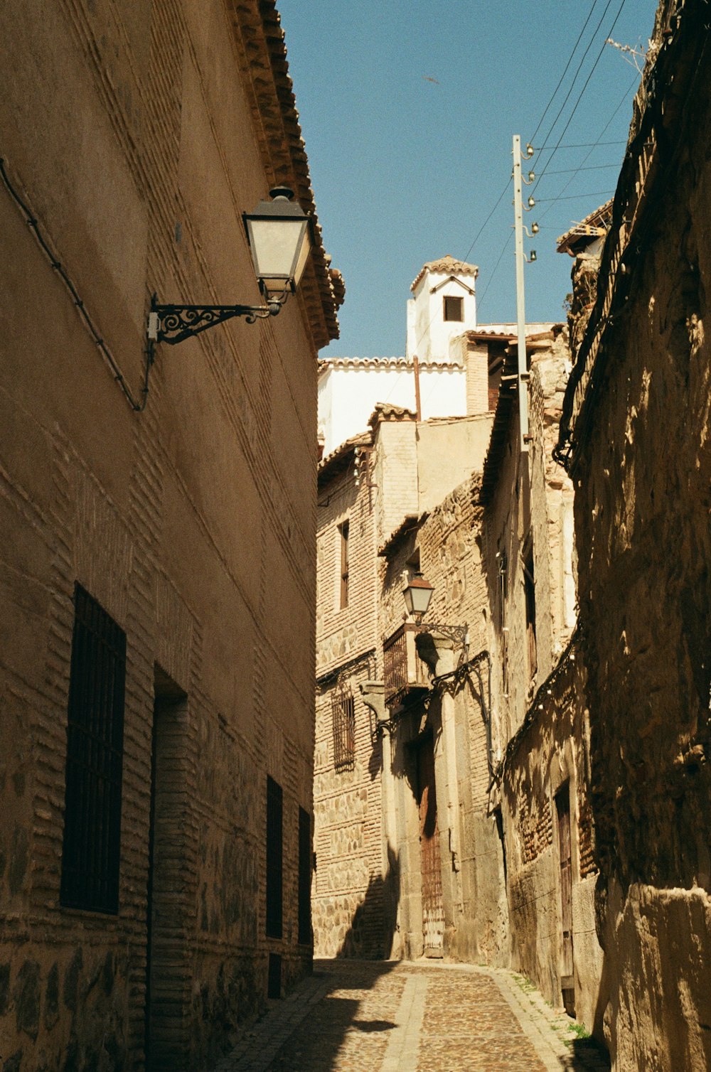 a narrow alley with a clock tower in the background