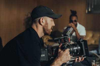 a man holding a camera in front of a woman
