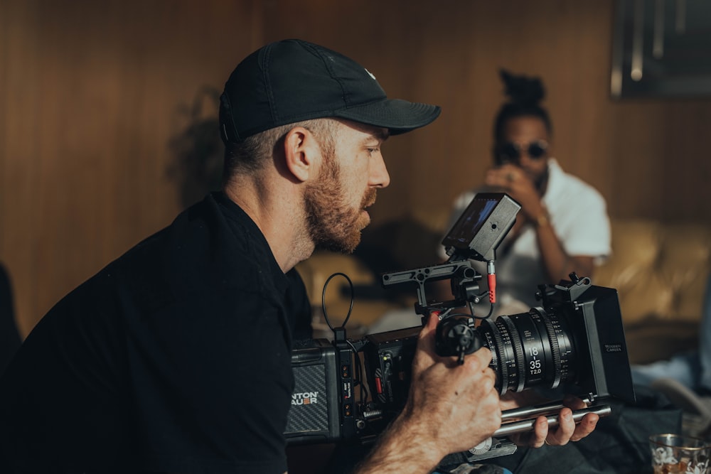 a man holding a camera in front of a woman