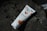 A tube of Bio'l Beauty Argan Oil cream lies on a dark rock surface, surrounded by shadows of leaves. The packaging features orange fruit illustrations, suggesting a natural theme.