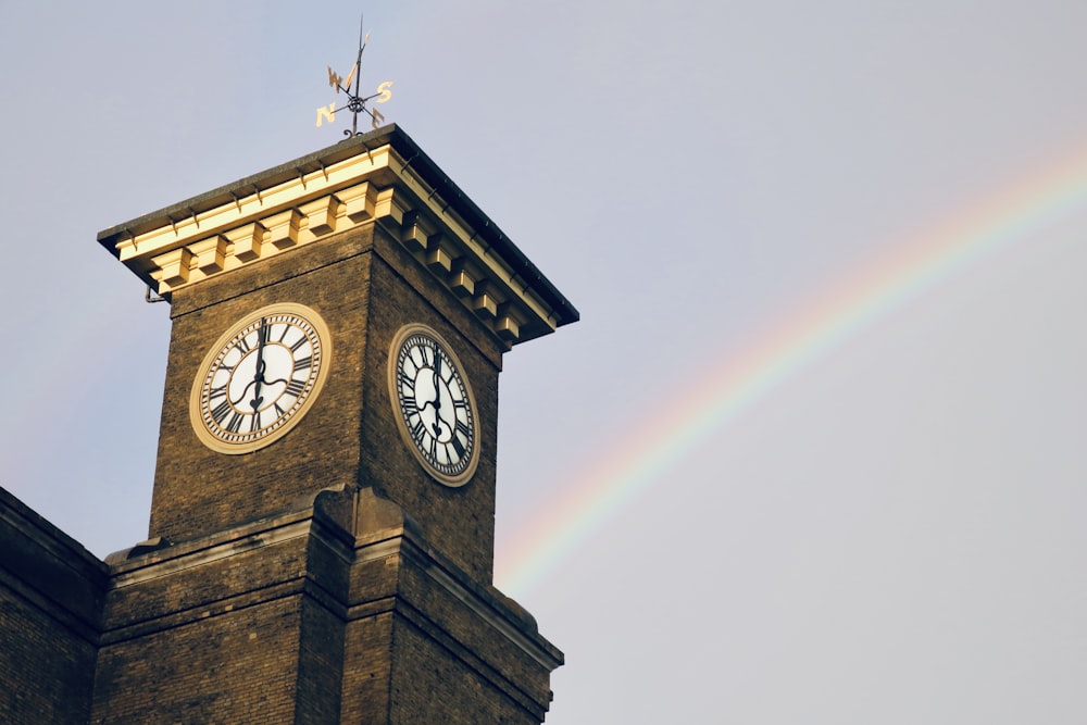 a clock tower with a rainbow in the background