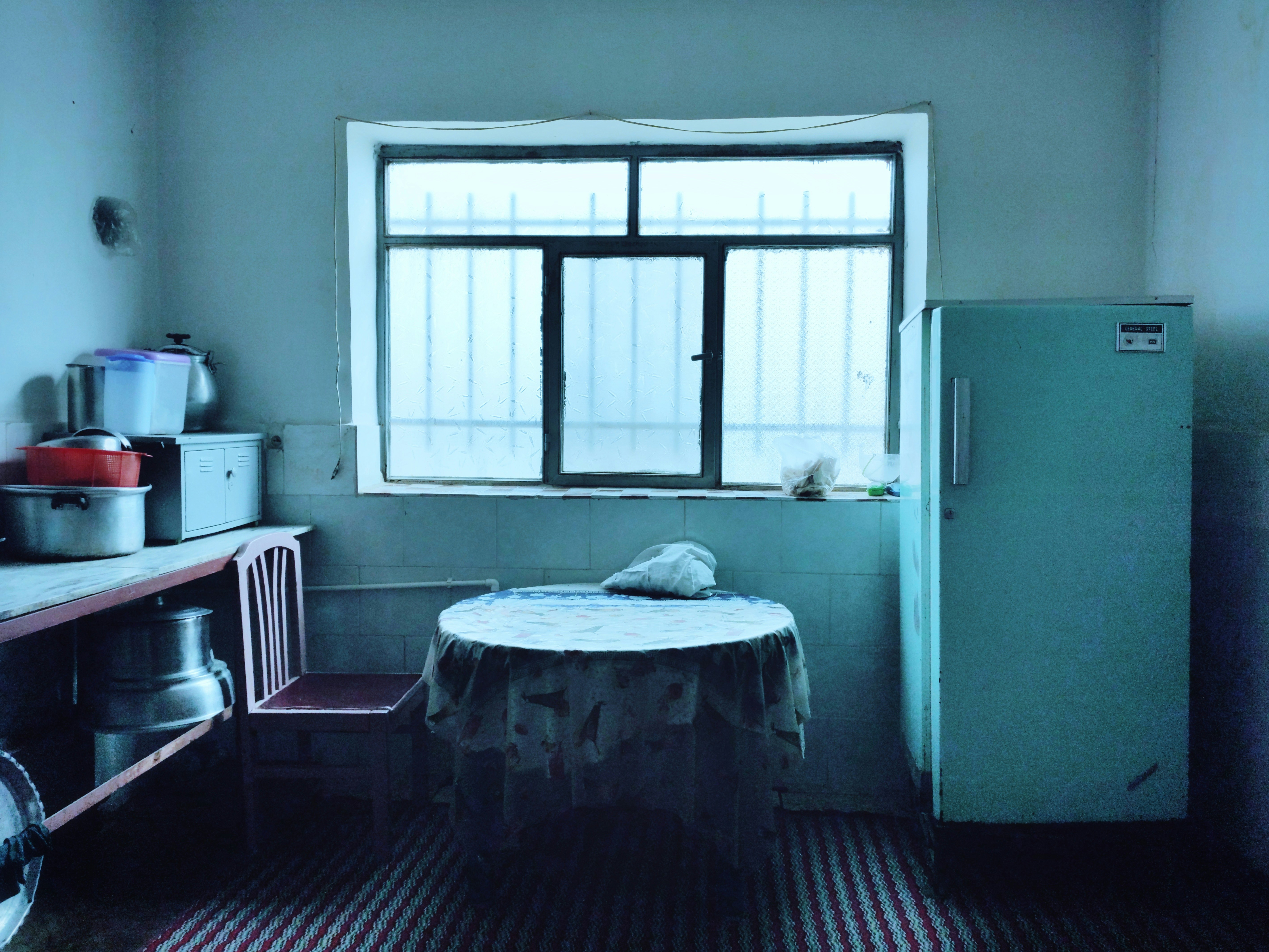 a kitchen with a table and a refrigerator