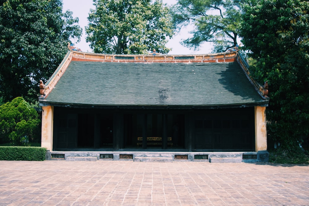 a building with a roof and a brick walkway in front of it