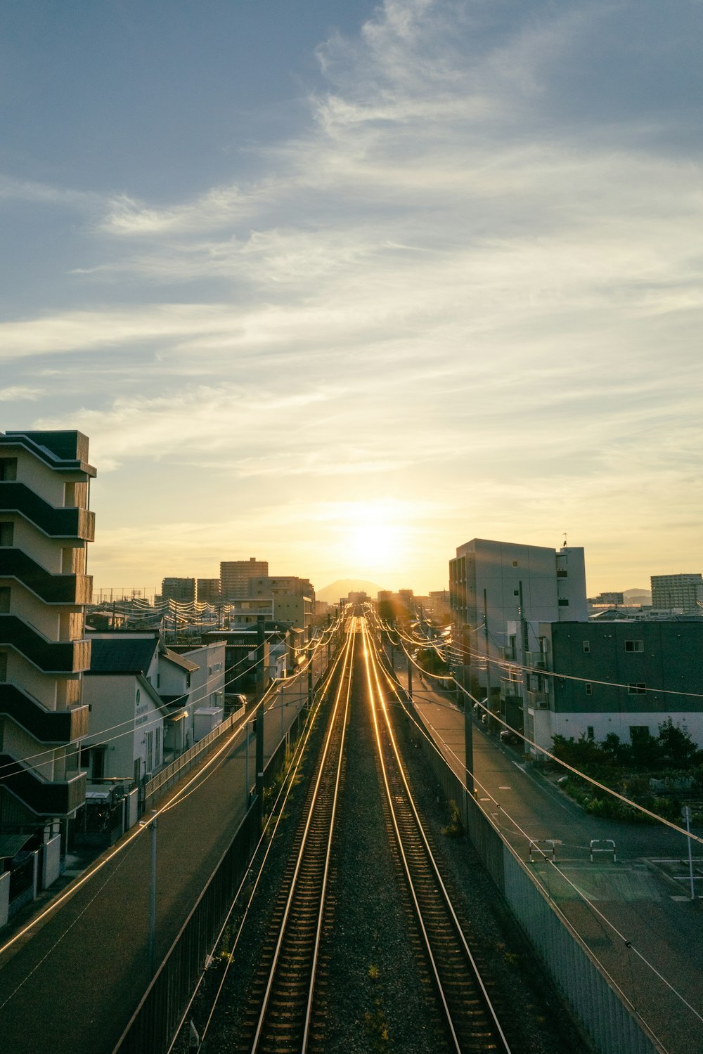 a train track with the sun setting in the background