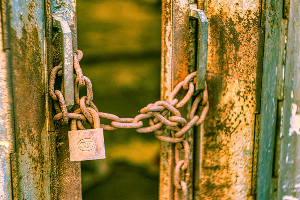 a rusted metal door with a padlock and chain