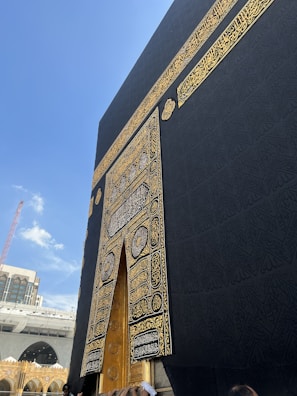 A serene close-up photo of the Kaaba's intricate black cloth with golden embroidery.