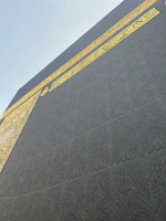 Close-up of intricate Arabic calligraphy on a textured parchment with gold accents.