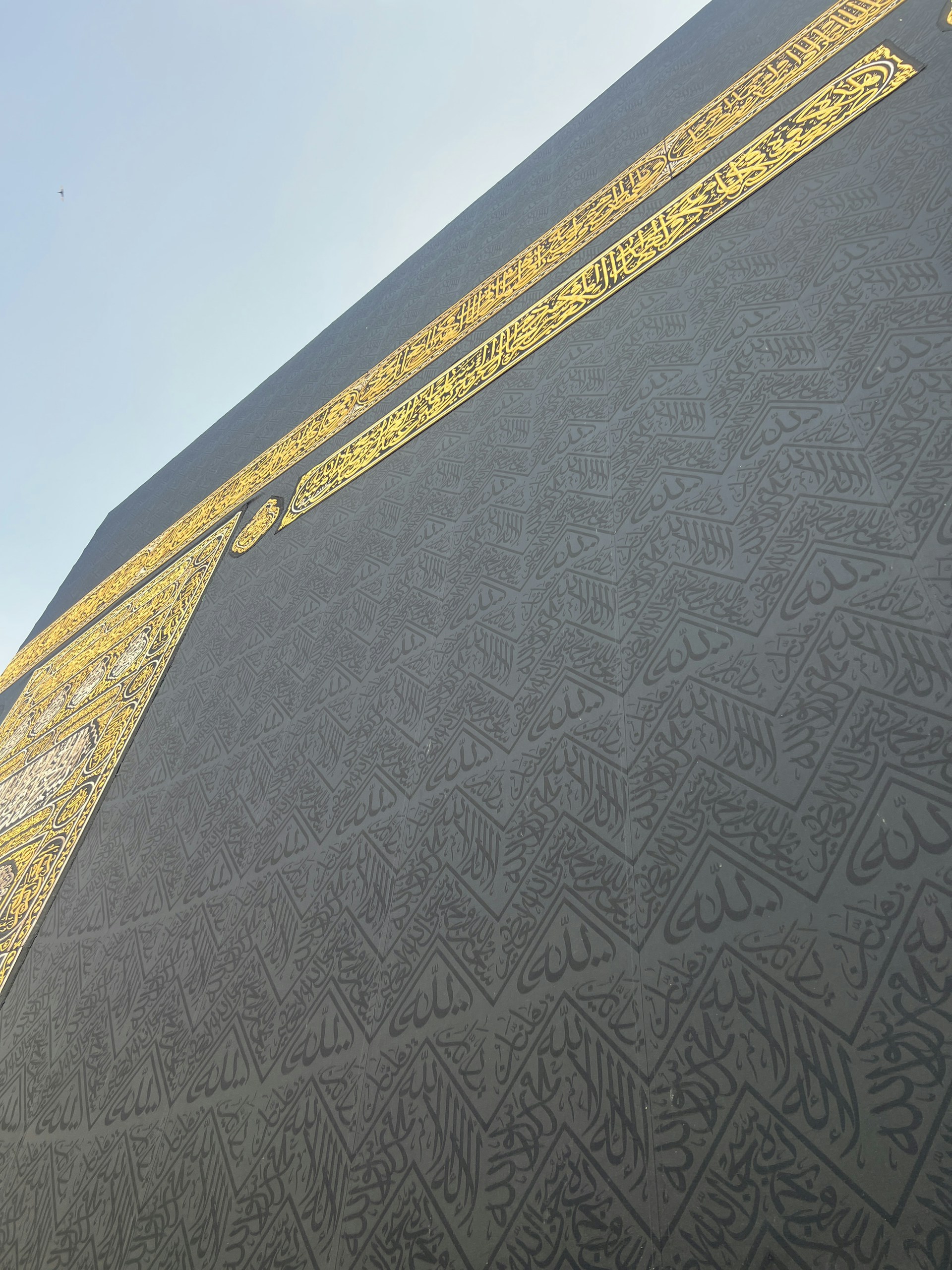 A serene blue sky background with delicate Arabic calligraphy of a poem flowing gracefully from right to left.