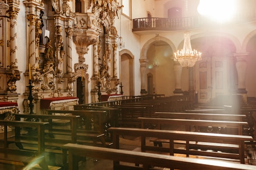 A warm, inviting chapel interior with soft light illuminating a choir singing during mass.