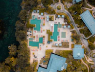 An aerial view of a luxury hotel resort surrounded by lush tropical gardens and crystal clear pools.