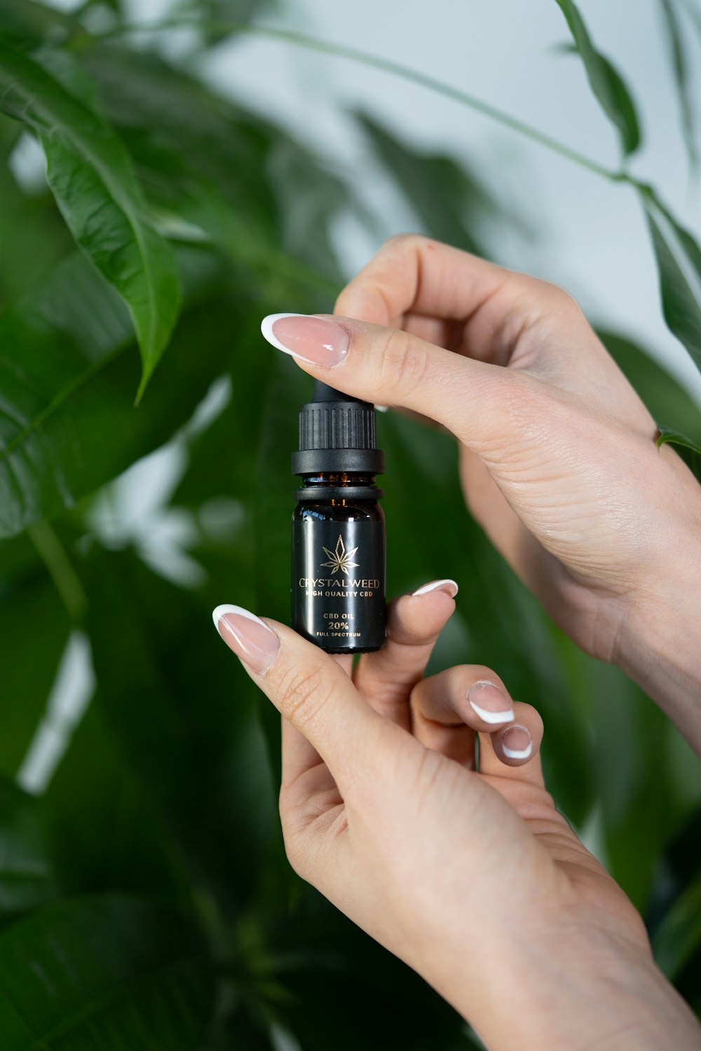 a woman holding a bottle of essential oil