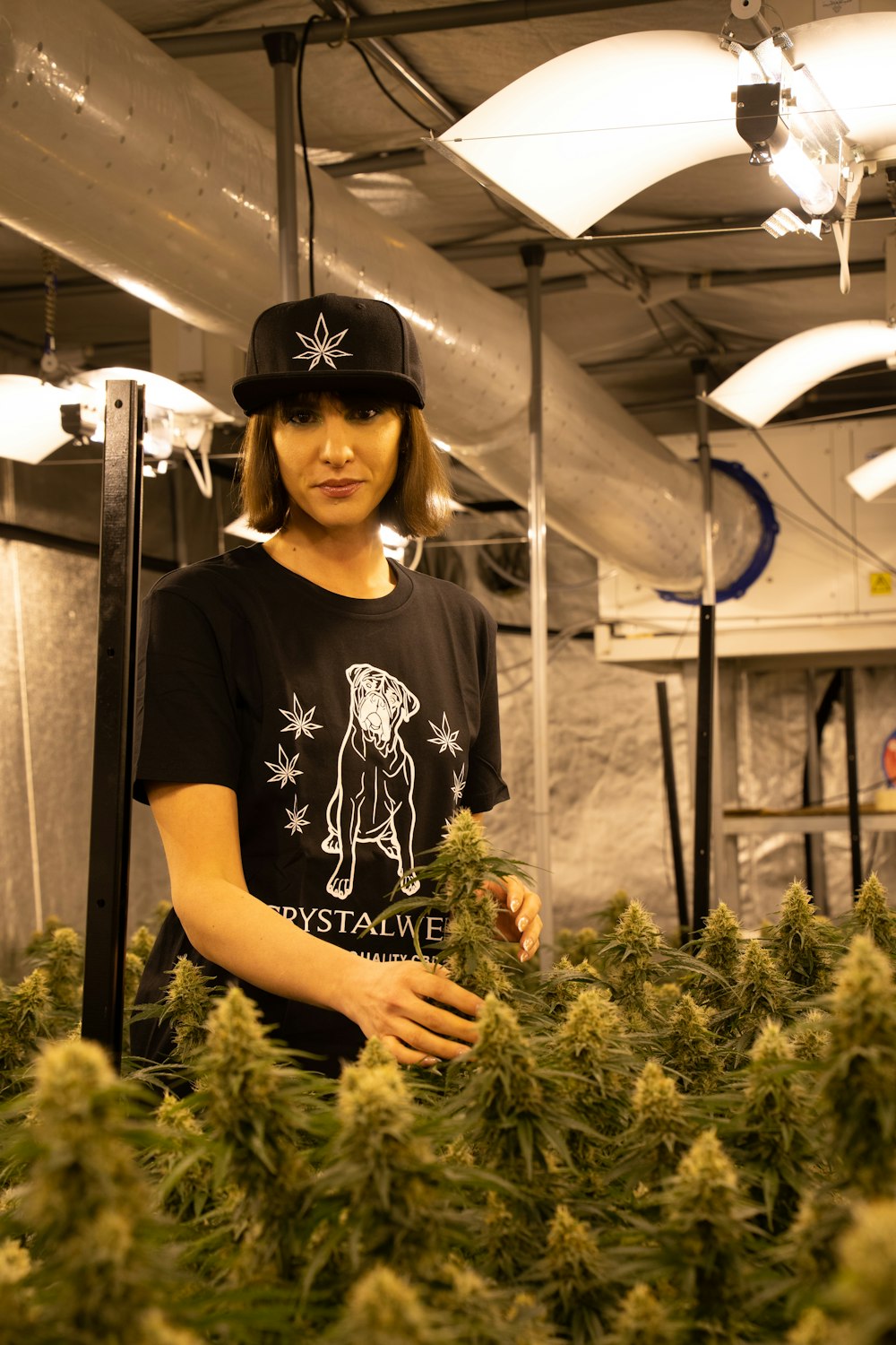 a woman standing in a room full of plants
