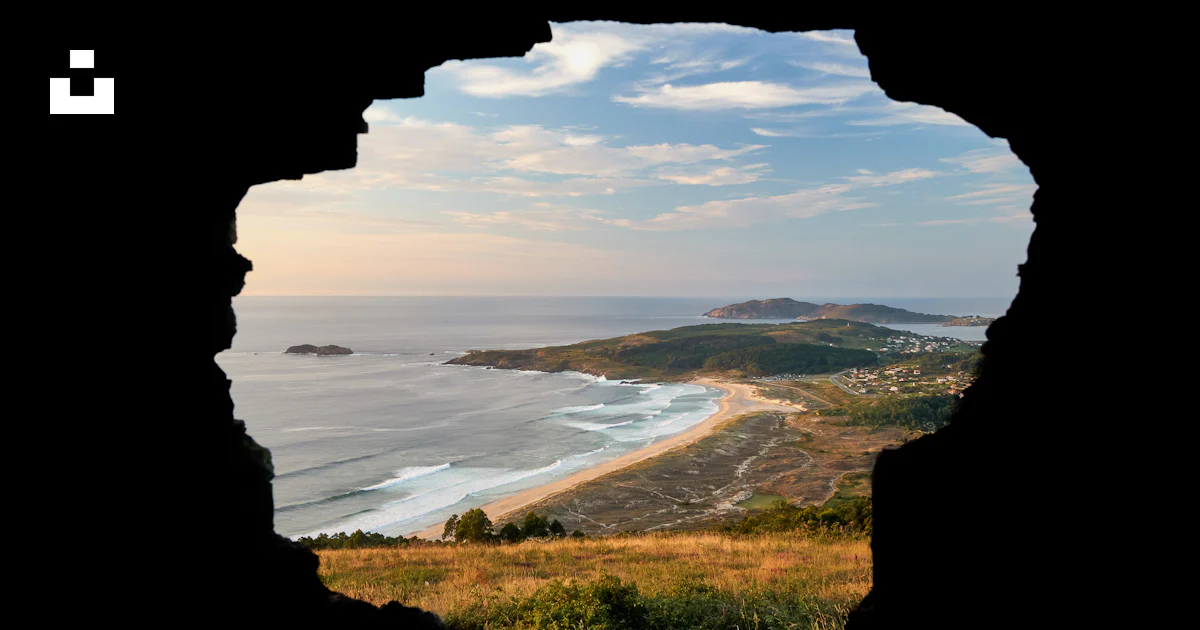 A view of a beach through a hole in a rock photo – Free Ferrol Image on ...