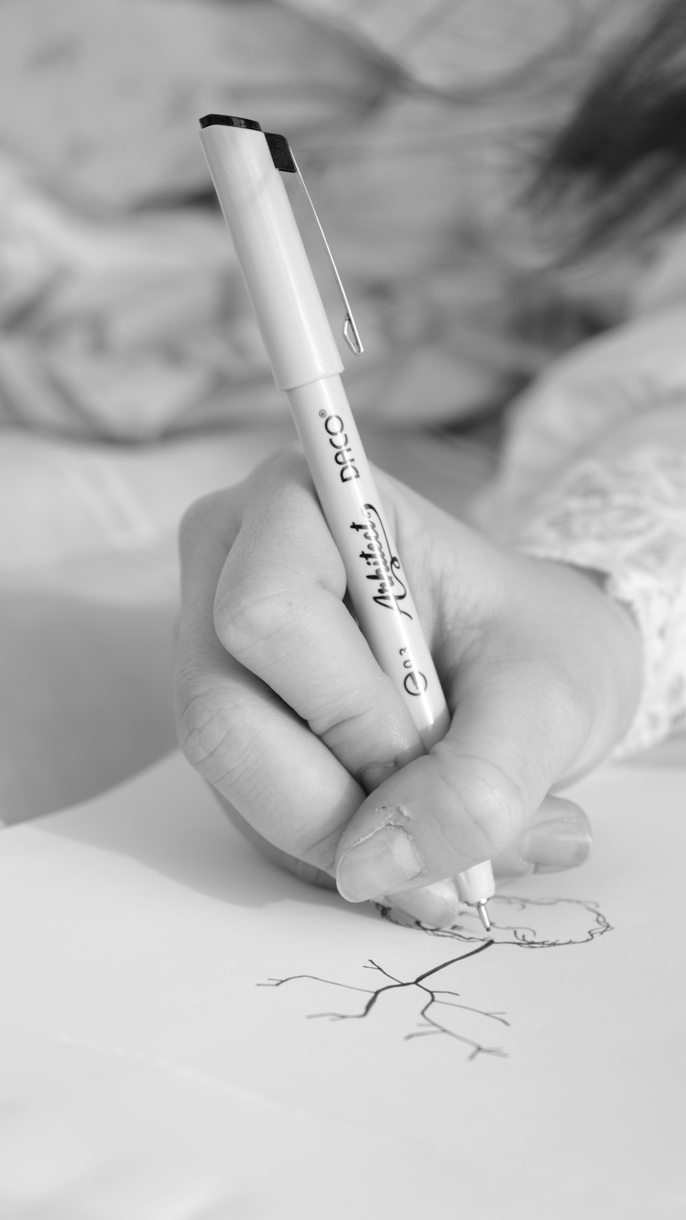 a person holding a pen and writing on a piece of paper