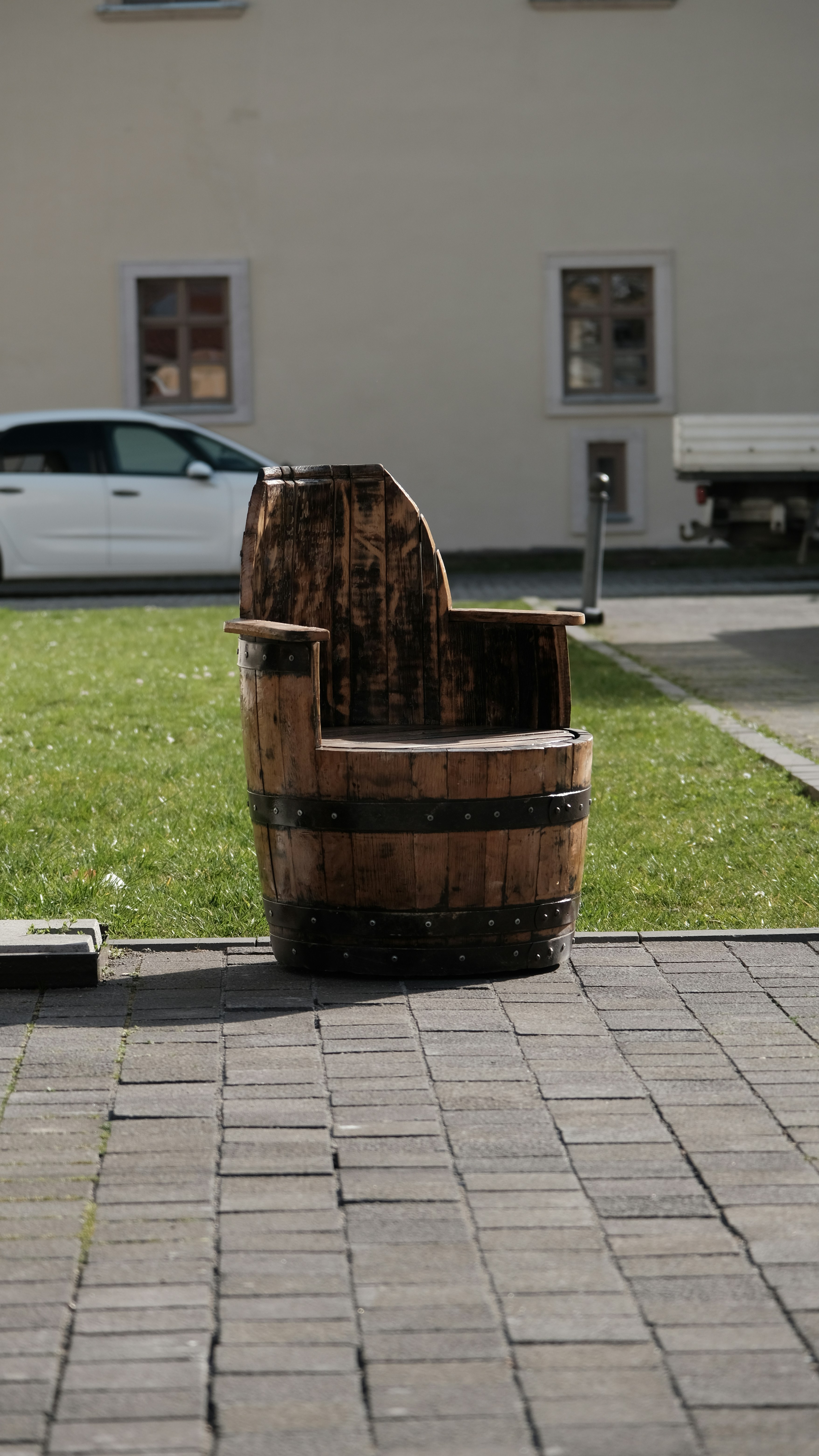 a wooden chair sitting on top of a brick sidewalk