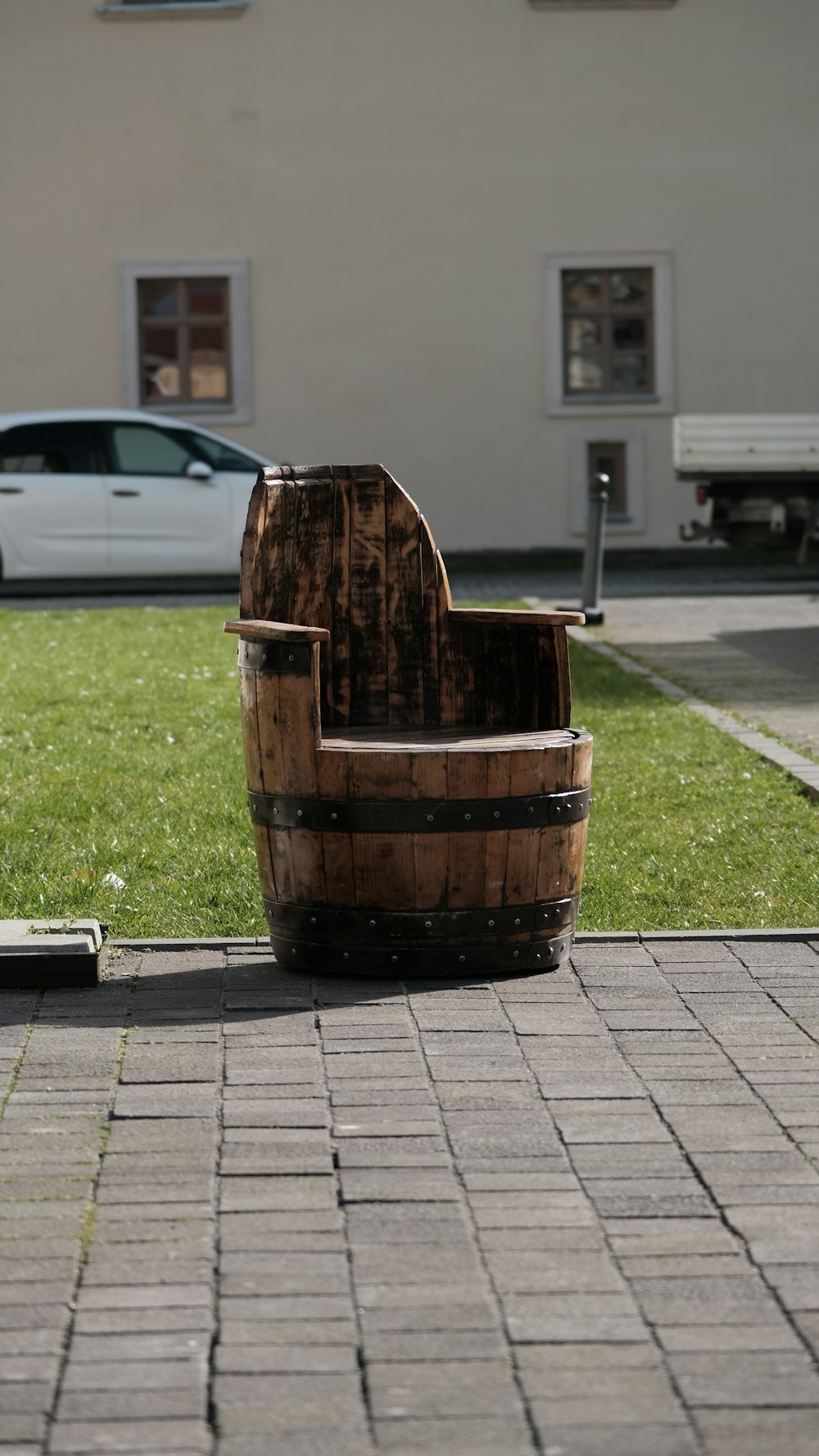 a wooden chair sitting on top of a brick sidewalk