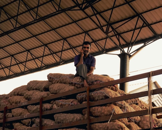 a man sitting on top of a pile of bread