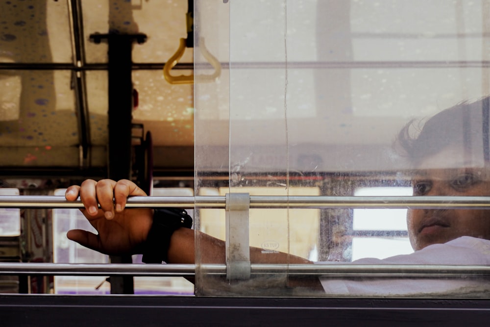 a man holding onto a rail in front of a window